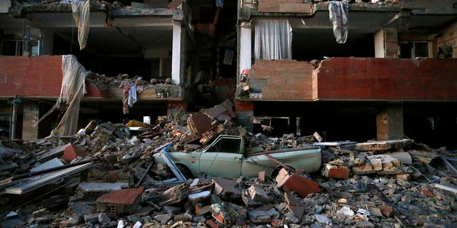 A car lays smashed by debris from the earthquake at the city of Sarpol-e-Zahab in western Iran on Monday.