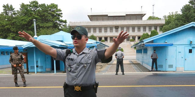 A South Korea army soldier gestures at the border villages of Panmunjom in Paju, South Korea.