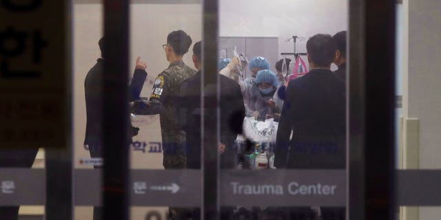 A South Korean army soldier, second from left, is seen as medical members treat an unidentified injured person, believed to be a North Korean soldier, at a hospital in Suwon, South Korea, Monday.