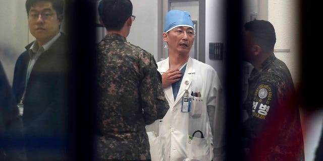 Doctors talk while treating a patient, believed to be a North Korean soldier, at a hospital in Suwon, South Korea.