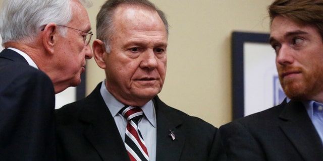 Former Alabama Chief Justice and U.S. Senate candidate Roy Moore listens as a campaign member talks to him before Moore speaks at the Vestavia Hills Public library on Saturday.