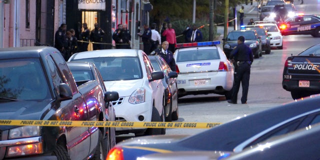 Police officers respond to Bennett Place and N. Fremont Avenue in Baltimore after a call went out that an officer is shot Wednesday.