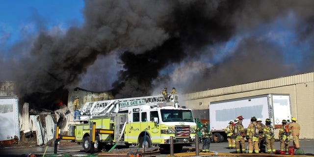Firefighters try to control a blaze at a cosmetics plant in New York on Monday.