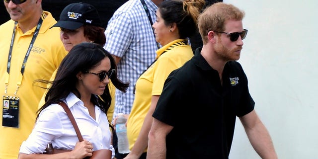 FILE - In this Monday, Sept. 25, 2017 file photo, Prince Harry and his girlfriend Meghan Markle arrive for the wheelchair tennis competition during the Invictus Games in Toronto. Palace officials announced Monday Nov. 27, 2017, Prince Harry and Meghan Markle are engaged, and will marry in the spring. (Nathan Denette/The Canadian Press via AP, File)