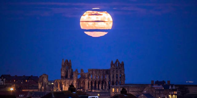 The supermoon rises above Whitby Abbey in Whitby, northeast England, on Sunday.