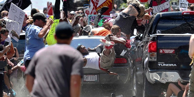 FILE - In this Aug. 12, 2017 file photo, people fly into the air as a vehicle is driven into a group of protesters demonstrating against a white nationalist rally in Charlottesville, Va. James Alex Fields Jr., the man accused of driving into the crowd demonstrating against a white nationalist protest, killing one person and injuring many more, has a preliminary court hearing Thursday, Dec. 14, 2017. (Ryan M. Kelly/The Daily Progress via AP, File)