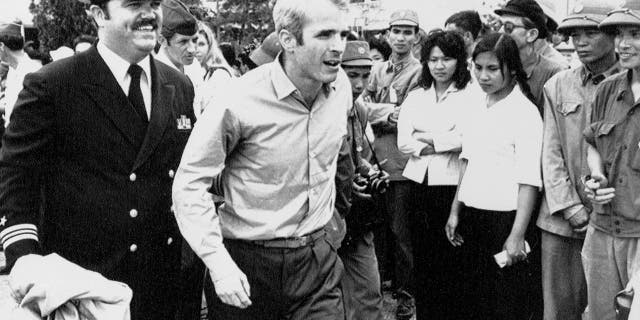 U.S. Navy Lt. Cmdr. John McCain, center, is escorted by Lt. Cmdr. Jay Coupe Jr., to Hanoi, Vietnam's Gia Lam Airport, after McCain was released from captivity.