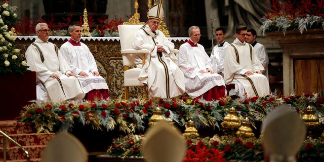 Pope Francis, background center, celebrates the Christmas Eve Mass in St. Peter's Basilica at the Vatican.