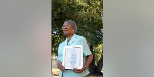 Recy Taylor, then 90, holds a photo of herself from her days in Abbeville, Ala., outside her home in Winter Haven, Fla.