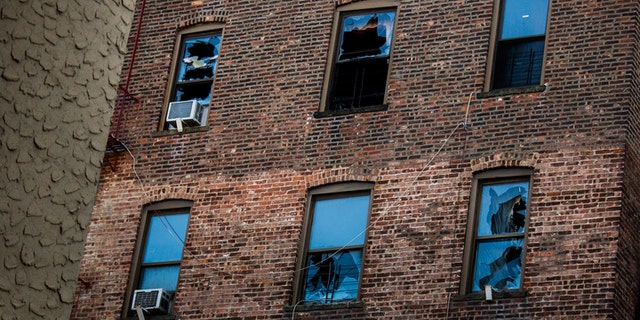 This photo shows broken windows on the back of the building where more than a dozen people died late last month. A fire broke out when a young boy played with the burners on his mother's stove, officials said.