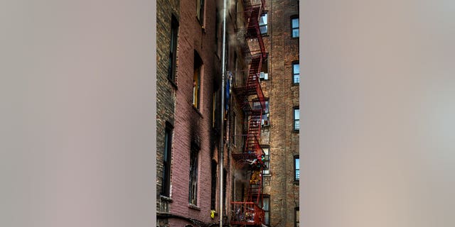 Smoke rises from a window of a burned apartment building in the Bronx.