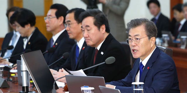 South Korean President Moon Jae-in, right, speaks during a cabinet meeting at the presidential Blue House in Seoul, South Korea, Tuesday, Jan. 2, 2018. South Korea on Tuesday offered high-level talks with rival North Korea to find ways to cooperate on next month's Winter Olympics in the South. 