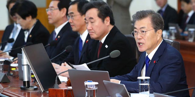 South Korean President Moon Jae-in, right, speaks during a cabinet meeting at the presidential Blue House in Seoul, South Korea, Tuesday, Jan. 2, 2018. South Korea on Tuesday offered high-level talks with rival North Korea to find ways to cooperate on next month's Winter Olympics in the South.