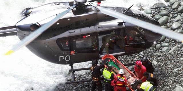Rescue workers load an injured man on a stretcher after he was retrieved from the bus.