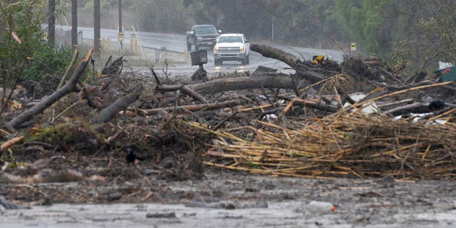 Debris from a swollen creek blocks Via Real in Carpinteria, California.