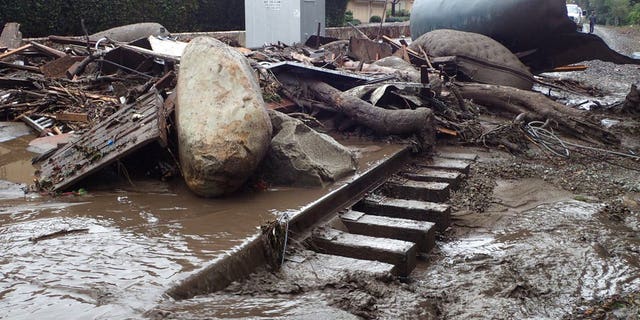 In this photo provided by Santa Barbara County Fire Department, the main line of the Union Pacific Railroad through Montecito, California is blocked with mudflow and debris due to heavy rains
