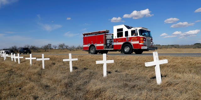 Ryland Ward looks out the passenger window as he passes a memorial of crosses as he returns home after his release from the hospital while riding in the cab of a firetruck on Jan. 11, in Sutherland Springs, Texas.