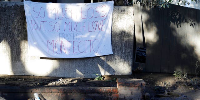 A sign is placed on a fence Saturday in the aftermath of a devastating mudslide.