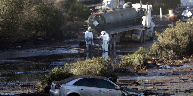 Crews pump mud on Highway 101 after a mudslide Saturday in Montecito, Calif.