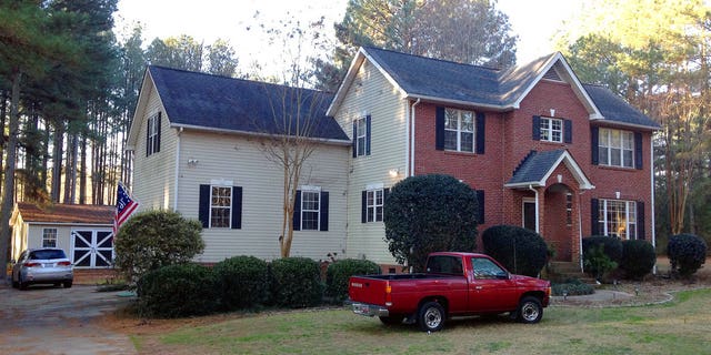 Cars are parked at a home in York, S.C. on Tuesday where multiple deputies responding to a domestic violence call were shot and wounded.