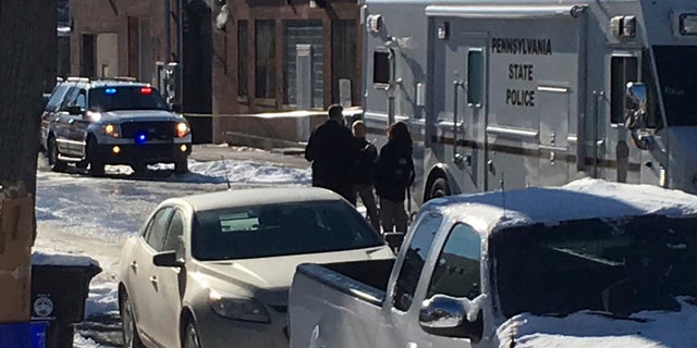 Law enforcement personnel are seen standing near the scene of a shooting in Harrisburg, Penn., on Thursday.