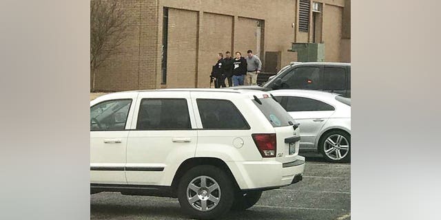 olice escort a person, second from right, out of the Marshall County High School after shooting there, Tuesday, Jan 23, 2018, in Benton, Ky.