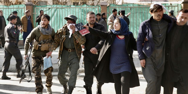 Wounded people are assisted at the site of an explosion in downtown Kabul, Afghanistan.
