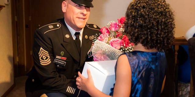 1st Sgt. Joseph Bierbrodt of Sheridan, Ill., with the 933rd Military Police Company, asks Cayleigh Hinton if he can escort her to the father-daughter dance at the Our Lady of Humility School
