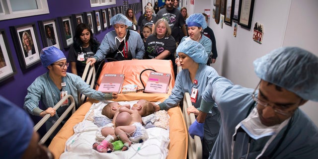 Hospital personnel wheel conjoined twins, Anna and Hope Richards, to surgery on Jan. 13. The girls who were born in 2016 were conjoined at the chest and abdomen.