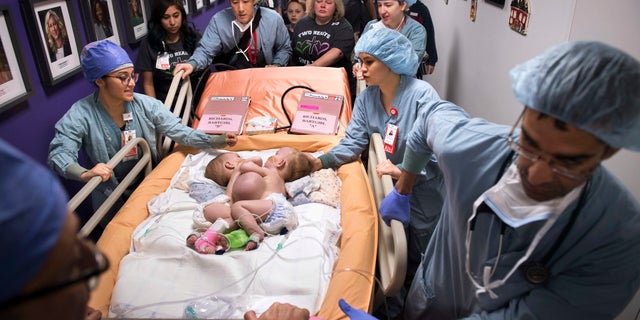 Hospital personnel wheel conjoined twins, Anna and Hope Richards, to surgery on Jan. 13. The girls who were born in 2016 were conjoined at the chest and abdomen.