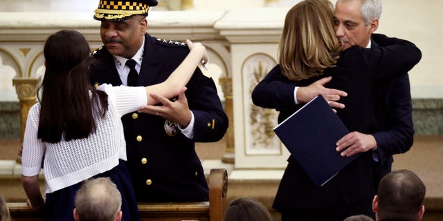 Chicago police Superintendent Eddie Johnson hugs Grace Bauer, 13, as Mayor Rahm Emanuel hugs Erin Bauer during the funeral Mass of Chicago police Cmdr. Paul Bauer on Saturday in Chicago.