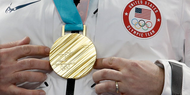 The United States' John Shuster puts his hands near his gold medal after winning the men's final curling match against Sweden at the 2018 Winter Olympics on Saturday.