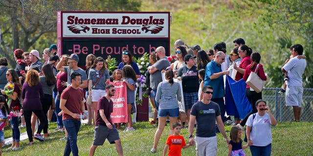 Parents and students arrive at Marjory Stoneman Douglas High School for an open house on Sunday, Feb. 25, 2018, in Parkland, Fla., as parents and students returned to the school for the first time since over a dozen were killed on Feb. 14.