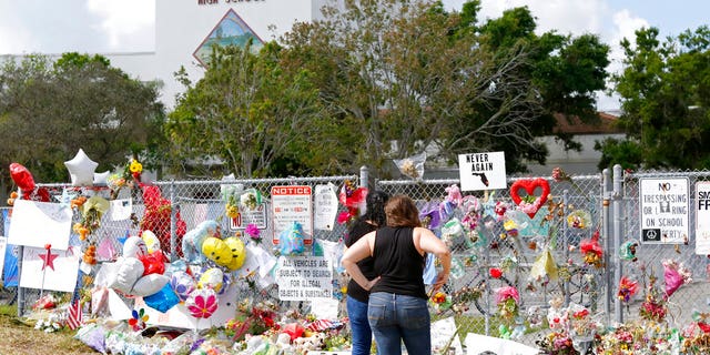 Mourners pay tribute at a memorial for the victims of the shooting at Marjory Stoneman Douglas High School on Sunday, Feb. 25, 2018, in Parkland, Fla.