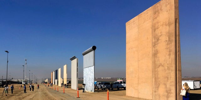 FILE - This Oct. 26, 2017 file photo shows prototypes of border walls in San Diego. A federal judge in San Diego who was taunted by Donald Trump during the presidential campaign has sided with the president on a challenge to building a border wall with Mexico. U.S. District Judge Gonzalo Curiel on Tuesday, Feb. 27, 2018 rejected arguments by the state of California and advocacy groups that the administration overreached by waiving laws requiring environmental and other reviews before construction could begin. (AP Photo/Elliott Spagat, File)