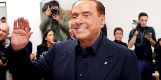 Italian former premier and leader of Forza Italia (Go Italy) party Silvio Berlusconi waves as he arrives at a polling station in Milan, Italy, on Sunday.