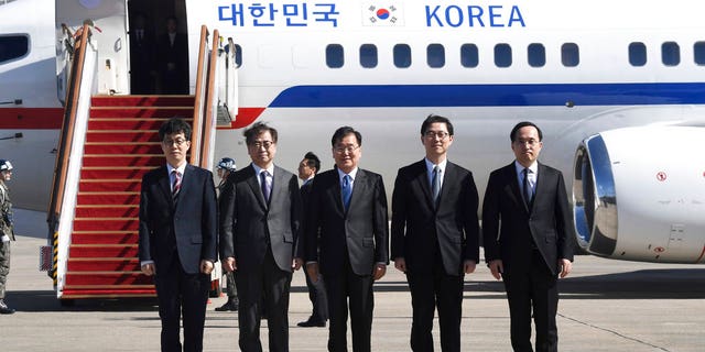 South Korea's national security director Chung Eui-yong, center, National Intelligence Service Chief Suh Hoon, second left, and other delegators pose before boarding an aircraft as they leave for Pyongyang at a military airport in Seongnam, south of Seoul, Monday, March 5, 2018.