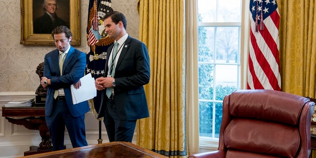 White House aide John McEntee, right, and Treasury Secretary Steve Mnuchin's Chief of Staff Eli Miller, left, stand in the Oval Office. McEntee recently rejoined the White House as the head of the Office of Presidential Personnel.