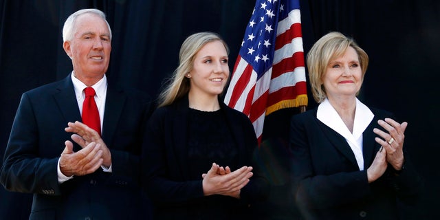 Cindy Hyde-Smith (right) stands with her husband, Mike Smith (left) and daughter Anna-Michael Smith (center) as the governor announces her appointment to the U.S. Senate.