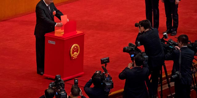 Chinese journalists film President Xi Jinping casting his ballot during a plenary session of China's National People's Congress at the Great Hall of the People in Beijing.