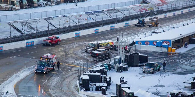 Titan Track Dryers work to clear the track at Martinsville Speedway in Martinsville, Va., Sunday, March 25, 2018. The NASCAR Cup Series race at Martinsville Speedway was postponed until Monday because of inclement weather. (AP Photo/Matt Bell)