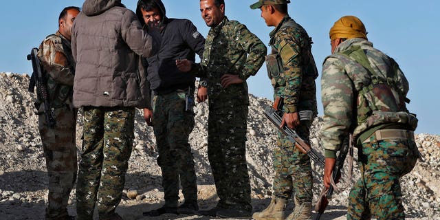 March 29: Commander Abu Ali Nejm, third from right, a leading member of the U.S-backed Syrian Manbij Military Council, speaks with his fighters at the front line against Turkish-backed fighters, at Halawanji village, north of Manbij town.