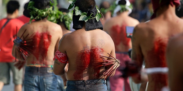 Filipino penitents line up as they flagellate during Good Friday rituals to atone for sins in San Fernando, Pampanga province, northern Philippines. The ritual is frowned upon by church leaders in this predominantly Roman Catholic country.