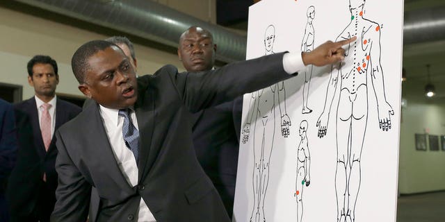 Dr. Bennet Omalu explains how police shooting victim Stephon Clark was struck by bullets, during a news conference in Sacramento, Calif., March 30, 2018.