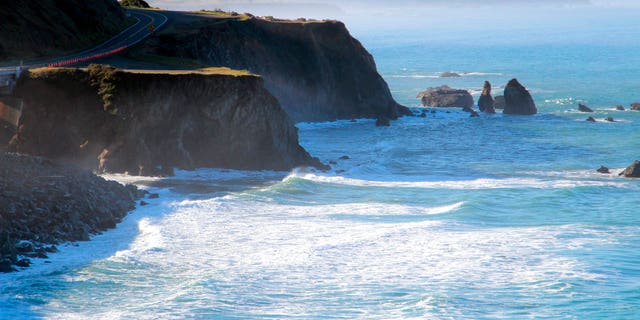 A helicopter hovers over steep coastal cliffs near Mendocino, Calif., where a vehicle plunged about 100 feet off a cliff. (AP)