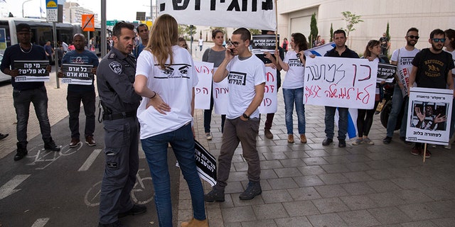 Israel announced a deal with the U.N. on Monday to resettle African migrants in Western nations, but hours later put the agreement on hold. A protester carries a sign written in Hebrew reading "Stop the deportation."