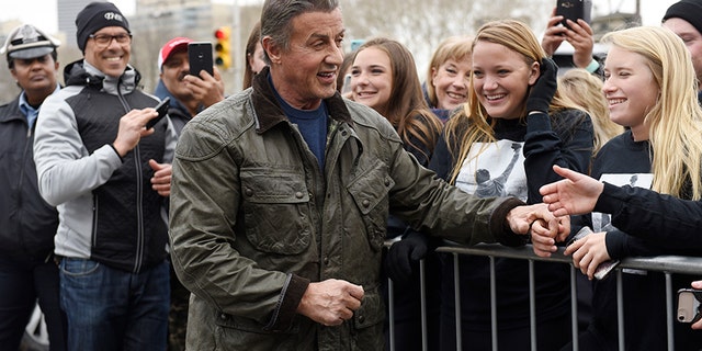 Sylvester Stallone greets a crowd as he walks to the Rocky statue at the Philadelphia Art Museum for a photo op with Philadelphia Mayor Jim Kenney on Friday.