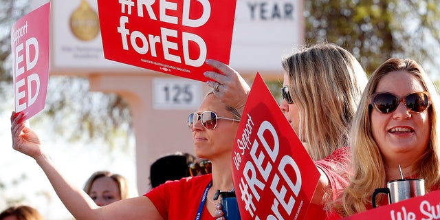 Teachers at Humphrey Elementary School in Chandler, Arizona, participate in a state-wide walk-in prior to classes on April 11.