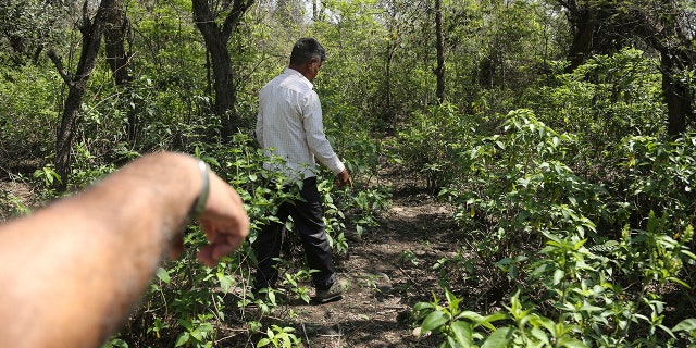 Indian men walk near the site where the body of of 8-year-old Asifa, who was raped and murdered, was found in Kathua district.
