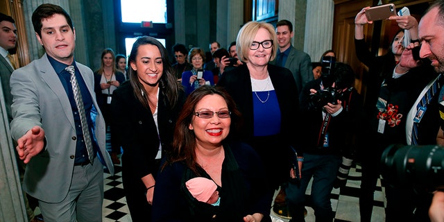 Sen. Tammy Duckworth, D-Ill., carries her baby Maile Pearl Bowlsbey as she heads to the Senate floor to vote, with Sen. Claire McCaskill, D-Mo., at right, on Capitol Hill, Thursday, April 19, 2018 in Washington. (AP Photo/Alex Brandon)